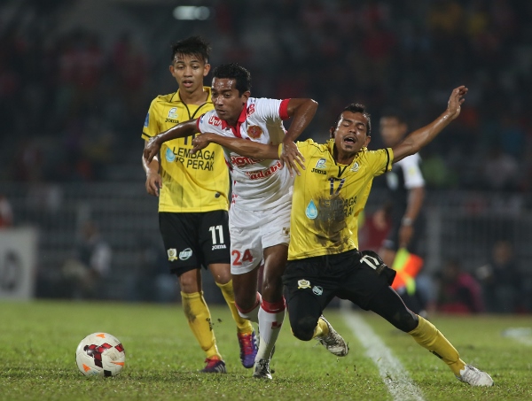 Kelantan's Zairul Fitree Ishak (second from left) fouls Perak's Muhamad Tuah Iskandar while attempting to get to the ball. Picture by ASIANA.MY