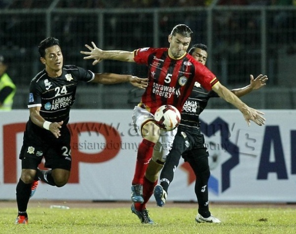 Milorad Janjus (center) of Sarawak is challenged by Perak's Mohamad Hisyamudin Mohamad Shaari in a Super League match yesterday. Sarawak won 1-0 with Janus hitting the winner from a freekick. Picture by AZAM MUHAMAD SUBRI/asiana.my