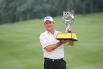 Scott Hend posing with the Tiger Trophy on the 18th hole